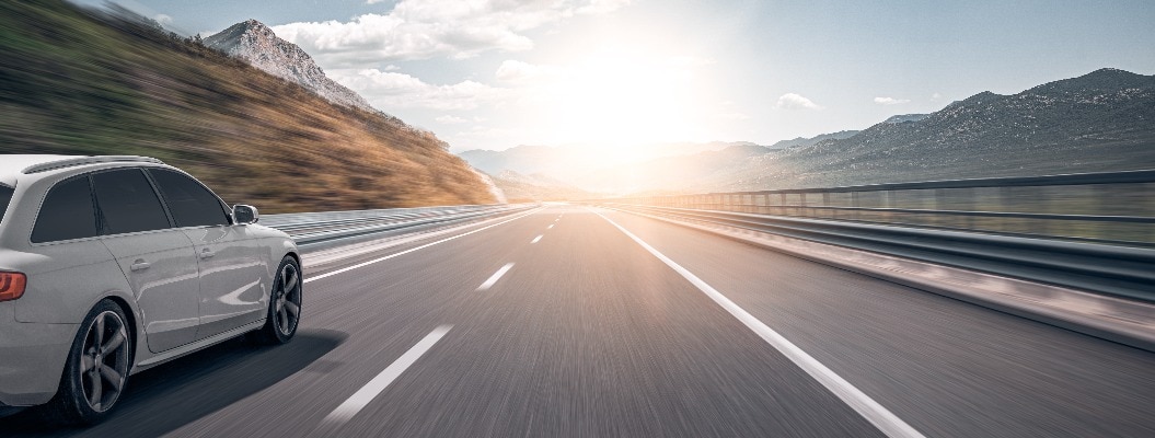 Ein Auto fährt die Straße entlang. Weißes Auto auf einer Vorstadtautobahn.