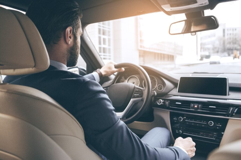 Junger Geschäftsmann bei einer Probefahrt mit einem neuen Auto