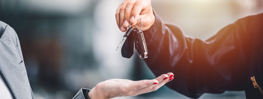 Nahaufnahme einer männlichen Hand, die einen Autoschlüssel für einen Autokredit übergibt